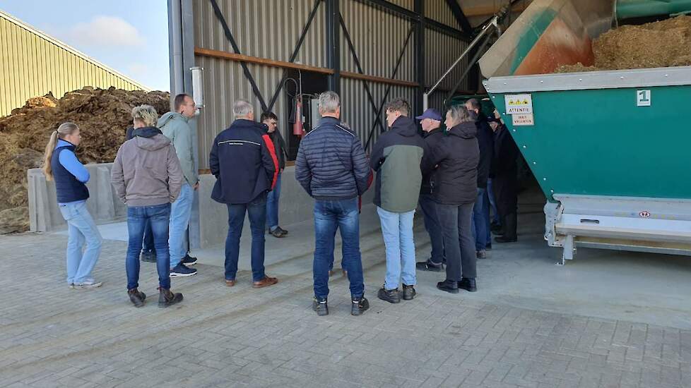 Melkveehouders bekijken het vullen van een automatisch voersysteem
