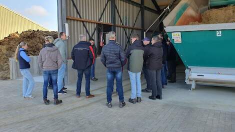 Melkveehouders bekijken het vullen van een automatisch voersysteem