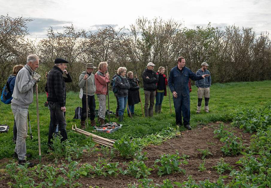 Akkerbouwer Wouter Vierboom geeft uitleg aan de vrijwilligers. Uiterst rechts bio-teler Howard Koster.