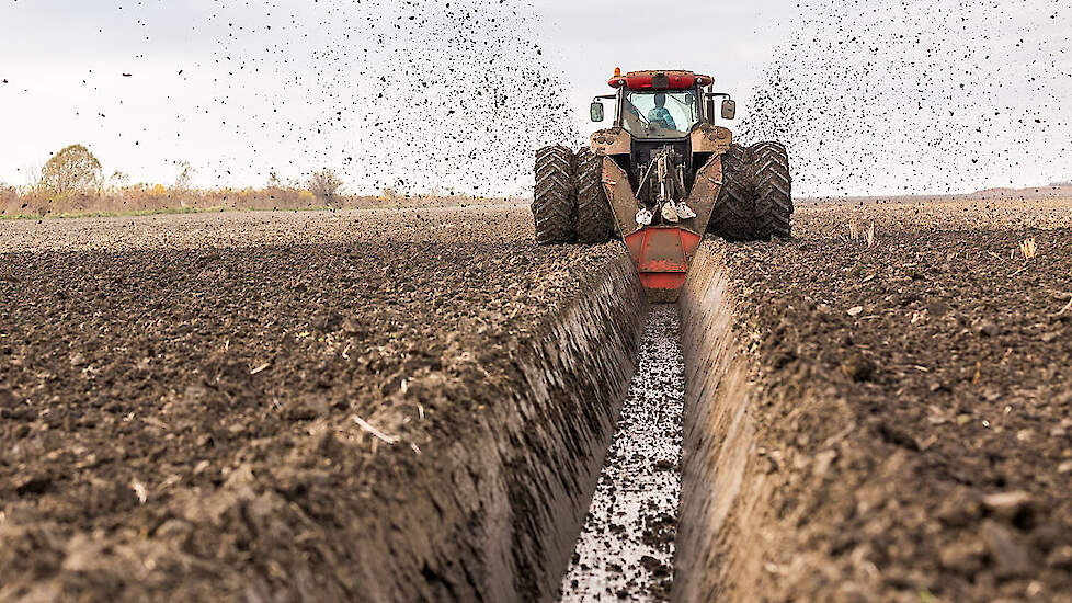 Tractor with double wheeled ditcher digging drainage canal - oticki via shutterstock
