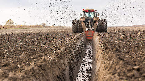Tractor with double wheeled ditcher digging drainage canal - oticki via shutterstock