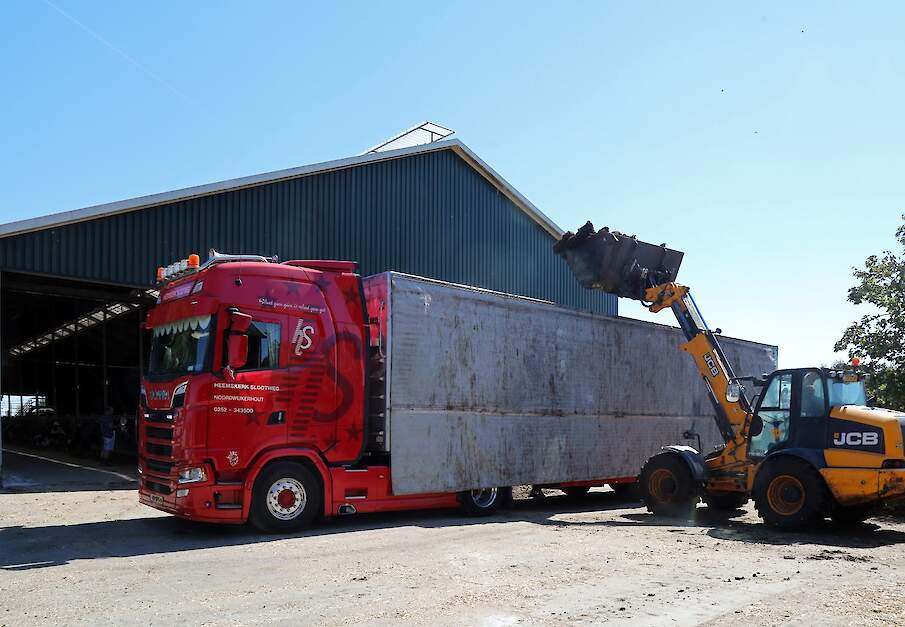 Een vrachtwagen wordt volgeladen met mest