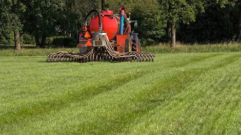 Tractor rijdt drijfmest op grasland