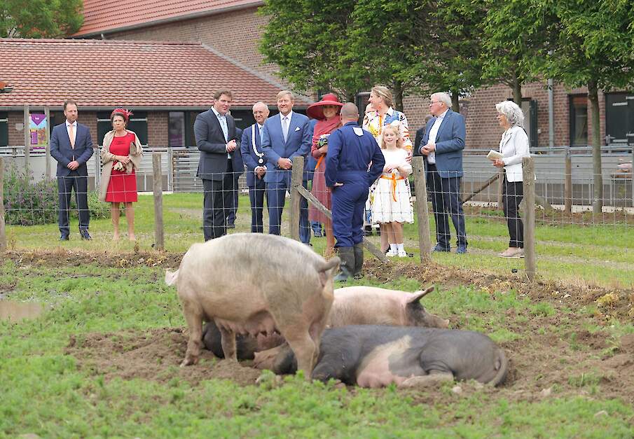 In de kloostertuin geeft Livar-directeur De Rond uitleg aan het Koningspaar over hun manier van varkens houden. V.l.n.r.: Frank de Rond, Burgemeester Jos Hessels, Koning Willem-Alexander, Koningin M&aacute;xima, medewerker Carlo Vaes, Merel de Rond- Postma, Roos