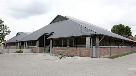 De achterkant van de 6+2 rijige ligboxstal met het karakteristieke zadeldak. De onderbouw van de oude stallen is helemaal blijven staan.