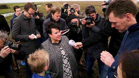 Melkveehouder Aldert Schilstra (rechts) staat staatssecretaris Sharon Dijksma (midden) te woord.