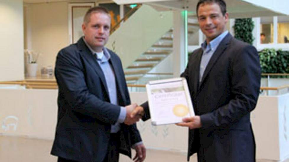 Johan Steenbergen (l) van Agrovision overhandigt het Gold Certificaat aan Arno Oostdam, commercieel directeur Agrifirm Feed